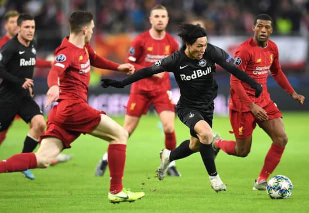 Salzburg's Japanese midfielder Takumi Minamino vies with Liverpool's Andrew Robertson. Picture: Joe Klamar/AFP via Getty