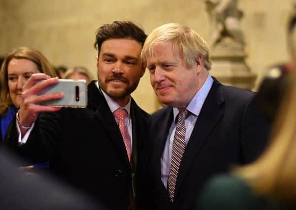 Boris Johnson poses for a selfie as he greets newly elected Conservative MPs in the Palace of Westminster (Picture: Leon Neal/pool/AFP via Getty Images)