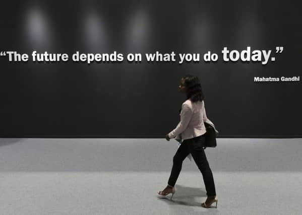 A participant walks past a wall showing a quote by Indian pacifist Mahatma Gandhi at the UN Climate Change Conference COP25 in Madrid earlier this month (Picture: Cristina Quicler/AFP via Getty Images)