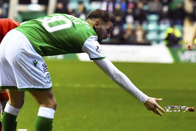 Hibs Martin Boyle with a glass bottle which had been thrown by a Hibs fan at stricken Rangers player Borna Barisic. Picture: Rob Casey/SNS
