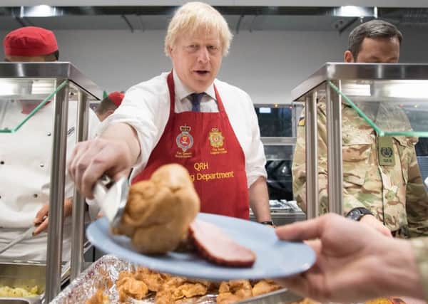UKs vaguely amusing Prime Minister, Boris Johnson, serves Christmas lunch to British troops in Estonia (Picture: Stefan Rousseau/PA Wire)