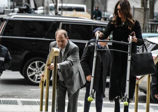 Harvey Weinstein's lawyer Donna Rotunno carries his walker up a flight of stairs as he arrives at the New York City criminal court for his sex crimes trial (Picture: Stephanie Keith/Getty Images)