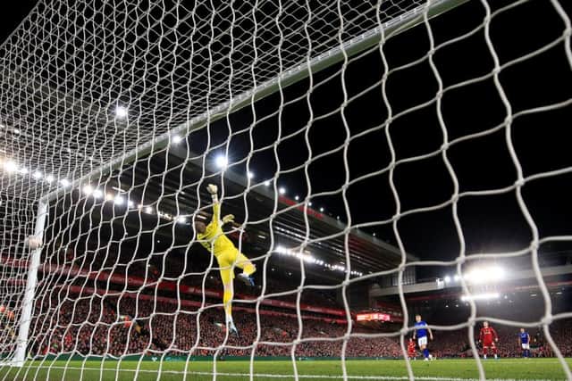 Everton keeper Jordan is left helplessly grasping air as Liverpool teenager Curtis Jones brilliant strike flies past him to clinch victory in the Merseyside derby. Picture: PA.