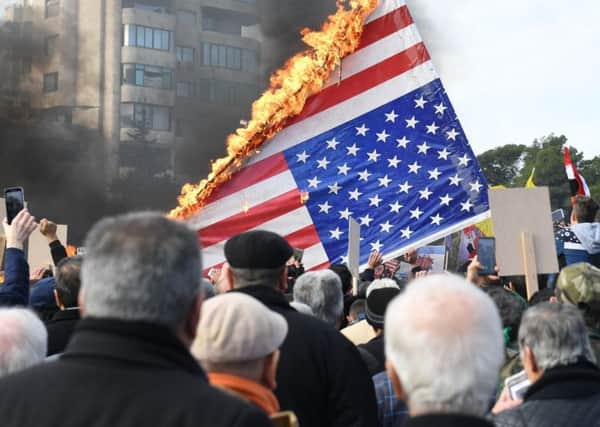 Syrian demonstrators burn the US flag as they gather in the northern Syrian city of Aleppo to mourn the death of Iranian military commander Qasem Soleimani and nine others in a US air strike in Baghdad. (Picture: AFP via Getty Images)