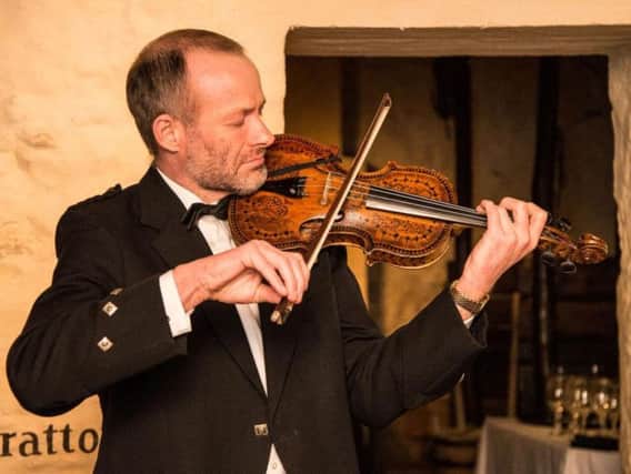Violinist Alistair McCulloch with the Gregg violin, which is believed to have been played by Robert Burns more than 250 years ago. PIC: Contributed.