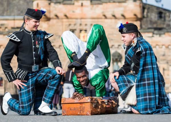 Adam Hill and Cameron O'Neill, of Pipers Trail, with Nigerian contortionist Aminu Haladu
 at last year's Royal Edinburgh Military Tattoo (Picture: Ian Georgeson)