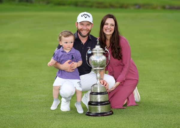 Branden Grace shows off the trophy along with his wife Nieke and their son, Roger. Picture: Getty.