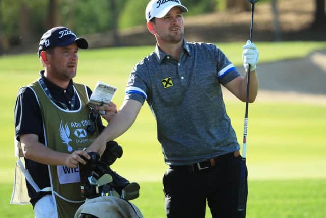 Austrian Bernd Wiesberger talks tactics with his caddie the third round of the Abu Dhabi HSBC Championship