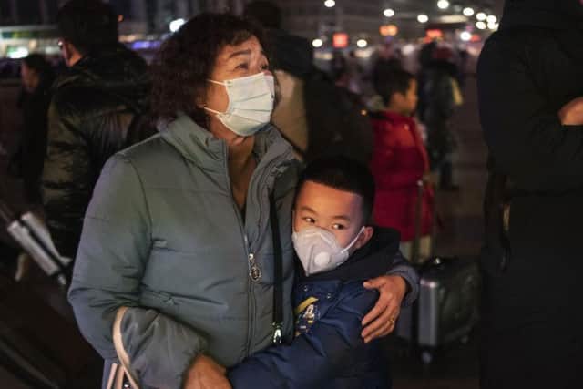 A Chinese boy hugs a relative as she leaves to board a train at Beijing Railway station. Travel in Wuhan, where coronavirus has broken out, has been severely restricted. Picture: Kevin Frayer / Getty Images