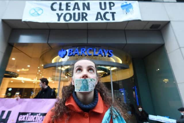 An Extinction Rebellion protester stands outside a Barclays Bank branch in Glasgow. Picture: John Devlin