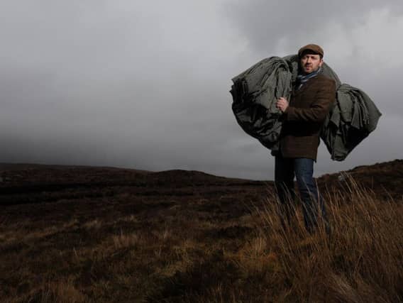 The Gaelic way of life is being used to draw visitors to the Outer Hebrides to experience an authentic way of life little changed over the generations. Pictured is weaver Billy Mathieson with a bolt of Harris Tweed near his home on Lewis. PIC: Robert Perry/TSPL.