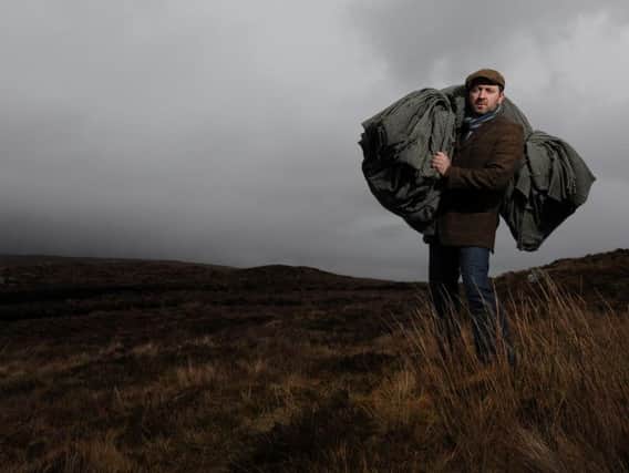 The Gaelic way of life is being used to draw visitors to the Outer Hebrides to experience an authentic way of life little changed over the generations. Pictured is weaver Billy Mathieson with a bolt of Harris Tweed near his home on Lewis. PIC:  Robert Perry/TSPL.