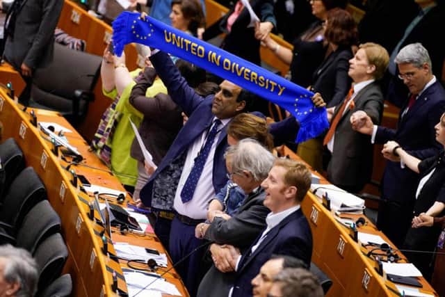 MEP Shaffaq Mohammed of the Renew Europe Group holds up a scarf with the lettering 'United in Diversity' during a vote on the ratification of the Brexit deal