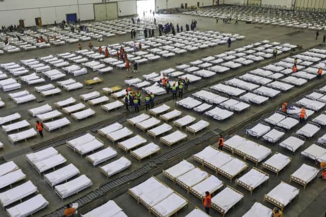 Workers arrange beds in a convention center that has been converted into a temporary hospital in Wuhan in central China's Hubei Province,