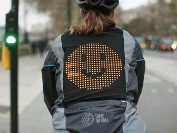 The jacket displays emojis on an LED panel.