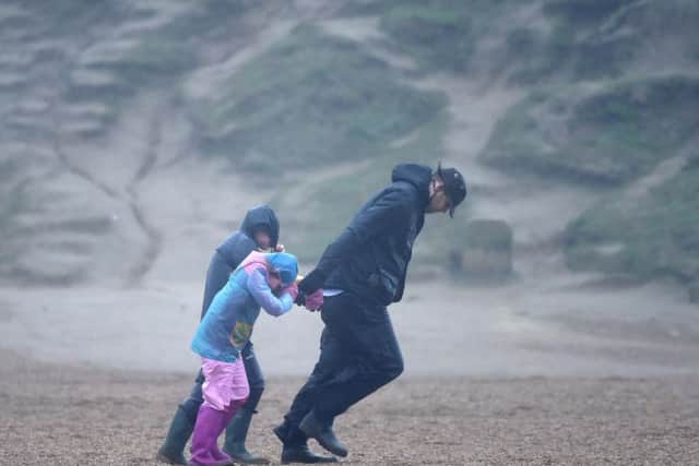 A man and his children battle the Storm Ciara winds at West Bay, UK. Picture: Getty