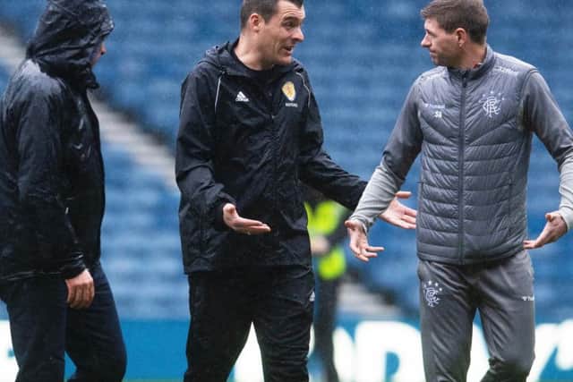 Rangers boss Steven Gerrard exchanges words with referee Don Robertson as officials and groundstaff inspect the Ibrox pitch
