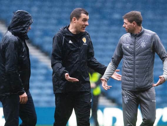 Rangers boss Steven Gerrard exchanges words with referee Don Robertson as officials and groundstaff inspect the Ibrox pitch
